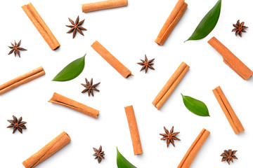 Aromatic cinnamon sticks and anise stars on white background