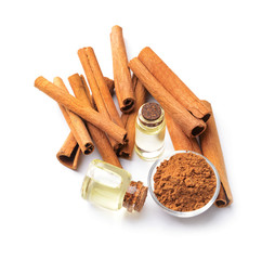 Aromatic cinnamon sticks and essential oil on white background