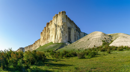 Panorama of the precipitous white limestone rock against clear sky