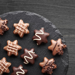 Star-shaped chocolates on dark textured background, copy-space
