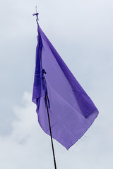 Purple flag on gray sky background
