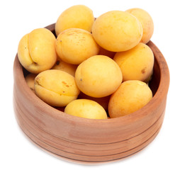 Ripe apricot in clay pot on a white background