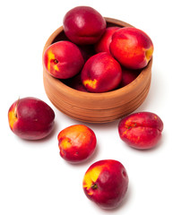 Ripe nectarine in clay pots on a white background