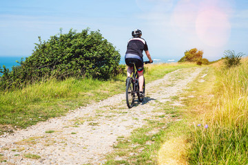 Fototapeta premium man doing mountain bike in a beautiful path with a sea view
