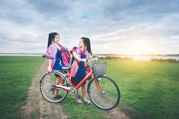 Obraz premium Beautiful Asian girls enjoy travel at countryside of Thailand by riding on bicycle