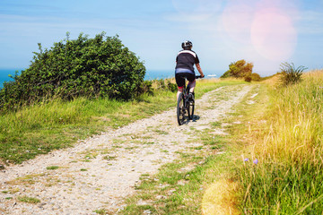 man doing mountain bike in a beautiful path with a sea view
