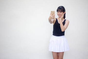 Portrait of thai adult beautiful girl black shirt white skirt using her smart phone Selfie