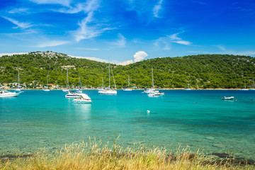 Scenic view of Kosirina beach bay on Murter island in Croatia, sailing boats and yachts on blue sea
