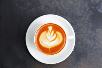Coffee in white cup on grunge wooden table