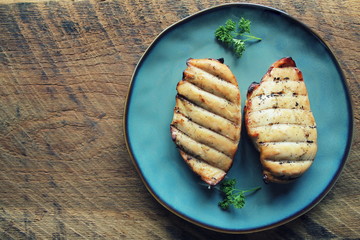 Grilled chicken breast on dark wooden background