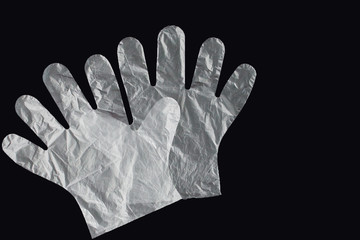 Plastic bag with handles, gloves, on a black background . Used plastic bag for recycling. Concept -...