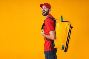 Photo of young delivery man in red uniform carrying backpack with takeaway food