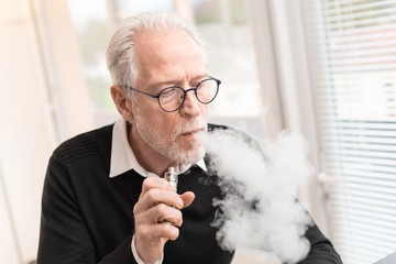 Senior man smoking electronic cigarette
