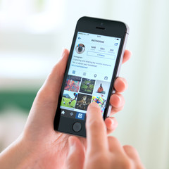 Outils professionnels Instagram KIEV, UKRAINE - MAY 30, 2014: Person holding an Apple iPhone 5S with an Instagram profile on the screen. Instagram is an online mobile social networking service, launched in October 2010.