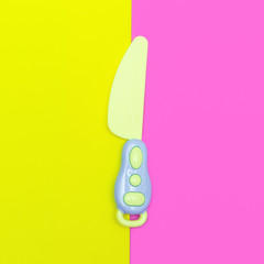 Toy plastic knife. Minimal flat lay art