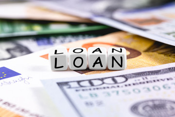 finance concept in blocks with word Loan. Closeup euros, dollars