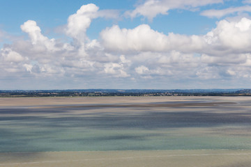 Lagoon at low tide with wonderfull clouds. Mont-Saint-Michel, Normandy, France