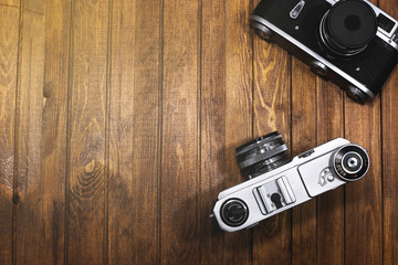 two vintage cameras on wooden boards background