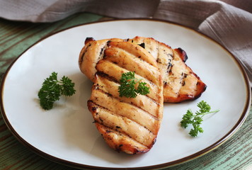 Grilled chicken breast on white plate