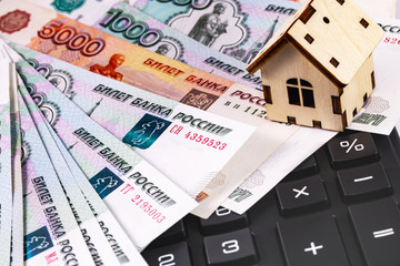 finance concept in house symbol and calculator with Russian money, rubles banknotes background