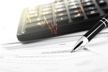 finance concept in paperwork, documents and black calculator, pen closeup