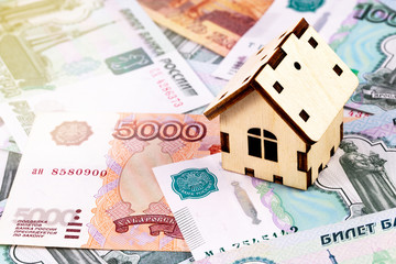 finance concept in wooden house on the Russian money, rubles banknotes background