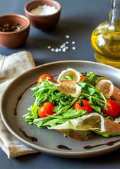 Salad with arugula, tomatoes and prosciutto. Italian cuisine. Healthy eating. Diet.