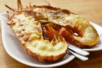 grilled lobster shrimp with cheese and butter garlic on plate