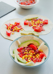 Mexican taco with vegetarian fillings on light table, cooking process