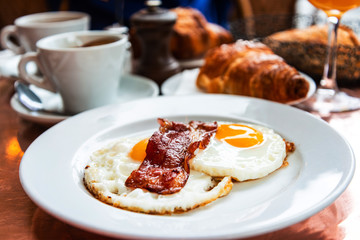 classical english breakfast with egg and croissants