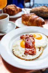 classical english breakfast with egg and croissants