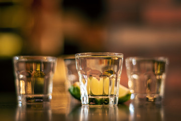 wodka shots on wooden table closeup