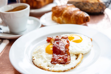 classical english breakfast with egg and croissants