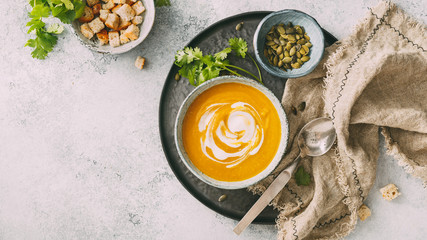 Pumpkin soup in a bowl with cream, top view. Copy spase. Autumn food.
