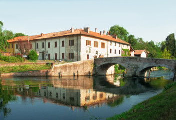 Fototapeta na wymiar summer landscape,medieval bridge over the Naviglio Grande near Milan. italy