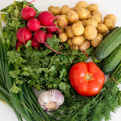 Vegetables lie on a white background, greens, tomato, potato