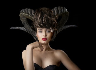 Girl with horns on black isolated background