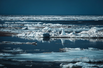 Winter ice floating along a northern shore.