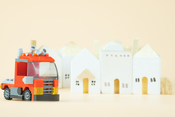 Fire truck plastic toy with village background.