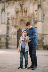 Fototapeta premium Two brothers look at the watch on theirs hands. Brother walking in the city