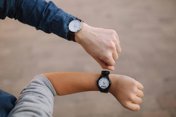 Hands with watch. Two brothers with watch in the city