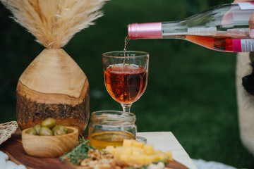 Rose wine, pouring from the bottle into the glass until it's full.