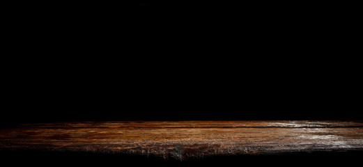 Wooden table background with black wall. Empty space for decoration and products.