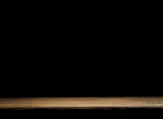 Wooden table background with black wall. Empty space for decoration and products.