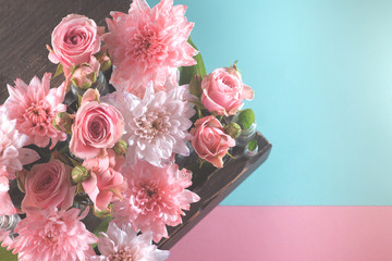 bouquet of pink roses and chrysanthemums on a delicate pink and blue background
