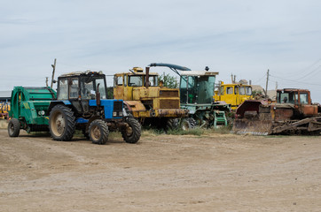 Obraz premium agricultural machinery such as tractor, plow, harrow stands in the field