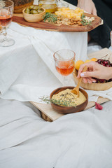 Woman hand scooping hummus with a spoon.