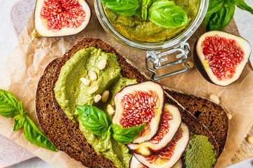 Pesto sauce sandwich with figs on rye bread, top view.
