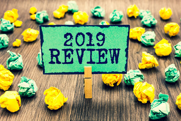 Text sign showing 2019 Review. Conceptual photo seeing important events or actions that made previous year Clothespin holding green note paper crumpled papers several tries mistakes