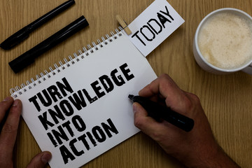 Text sign showing Turn Knowledge Into Action. Conceptual photo Apply what you have learned Leadership strategies Paperclip retain written notepad hand hold marker coffee black pen on woody desk